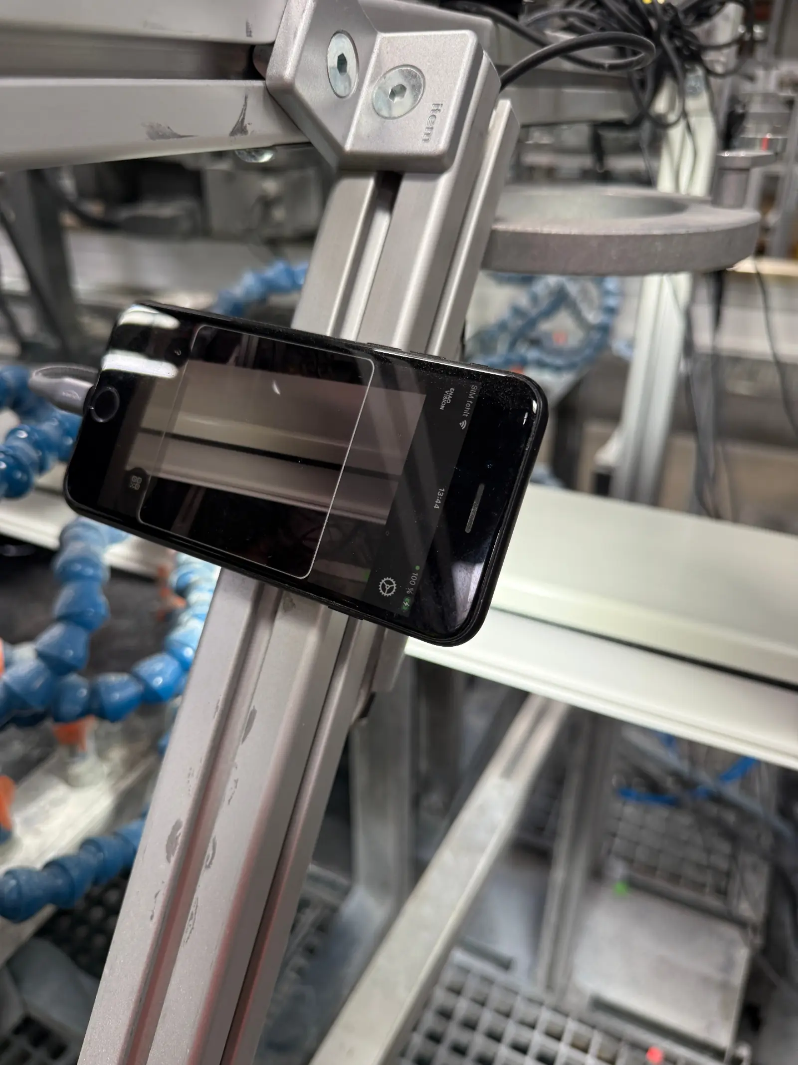 iPhone mounted on an aluminum frame above a production line